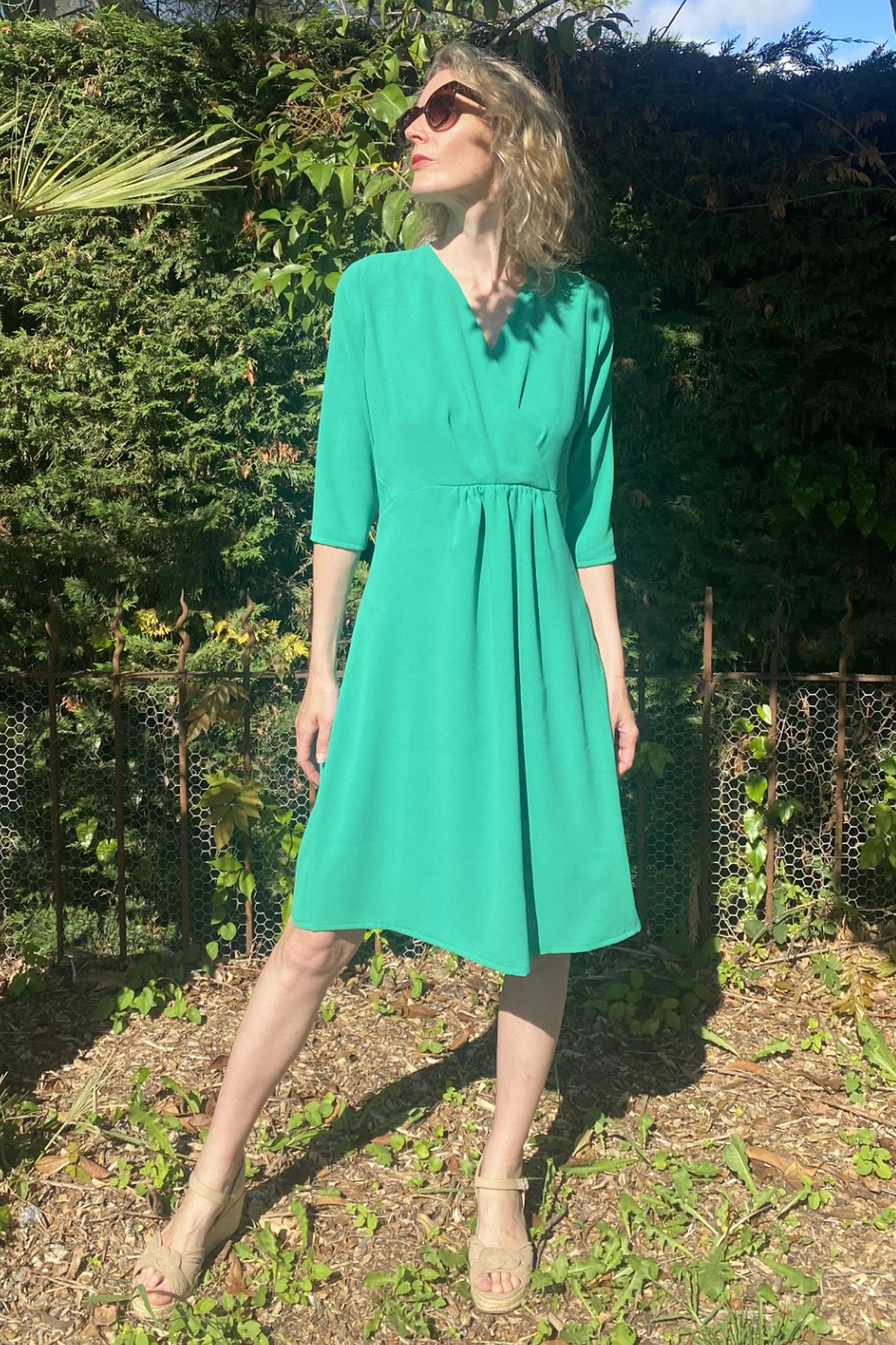 Jolie robe en polyester recyclé certifié Oeko-Tex®. Manches 3/4, décolleté croisé, empiècements triangles à la taille sur les côtés, petites fronces sous la taille devant, zip côté, longueur sous genou. 