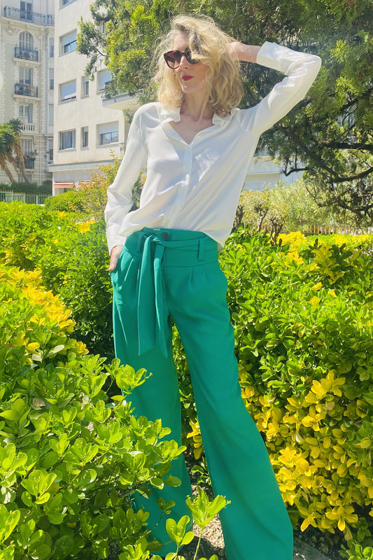 Pantalon large, taille haute, deux poches italiennes à l'avant, une large ceinture et une fermeture par zip surmontée de 3 boutons. Ce pantalon au tombé fluide présente deux pinces sur le devant.